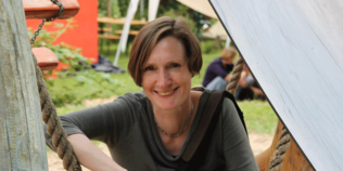 Anke Oxenfarth, Leiterin der Stabsstelle Nachhaltigkeit des Oekom-Verlages im Freien mit Personen im Hintergrund