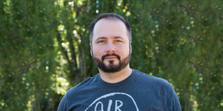 Adrian Krion, Managing Director Spielworks vor einem grünen Hintergrund