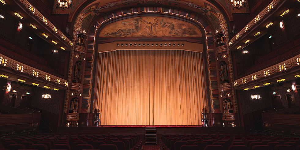 Blick in einen Kinosaal, der an ein Theater erinnert. 
