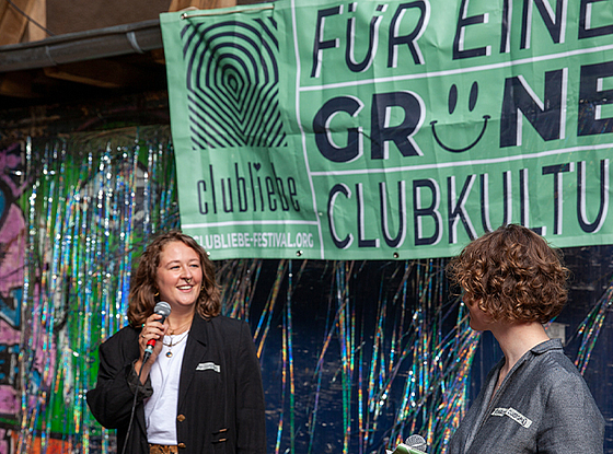 2 Frauen vor grünem Banner mit der Aufschrift: Für eine Grüne Clubkultur