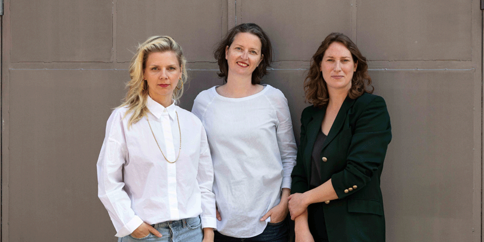 Tanja Wagner, Anne Schwanz und Johanna Neuschäffer von BerlinViews vor einer grauen Wand.